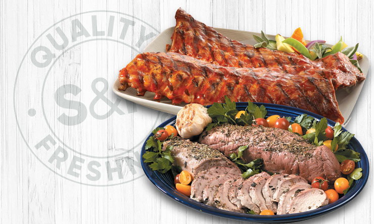 Pork loin and tenderloin cuts arranged for sale in a grocery store meat department.