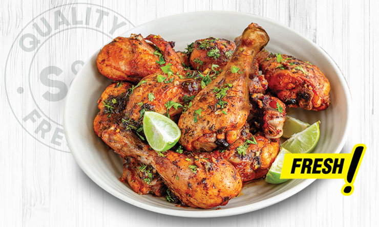 Fresh raw chicken drumsticks arranged in a tray."
