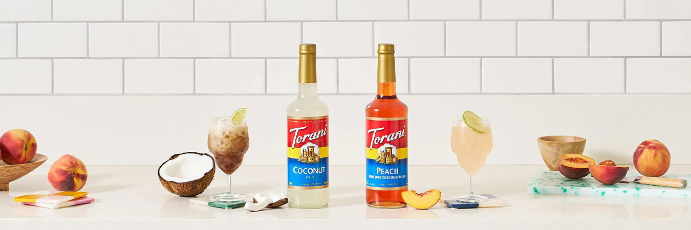 Torani flavored syrup products displayed in branded bottles, featuring the Torani logo, colorful labels, flavor names, and product information.”